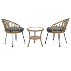 Ensemble de salle à manger d'extérieur 3 pièces comprenant une table basse ronde en verre avec étagère de rangement et 2 chaises en rotin avec coussins.