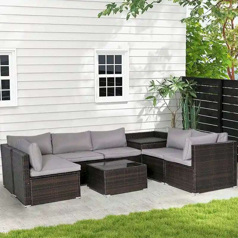 Ensemble de mobilier de jardin en rotin marron et gris 8 pièces comprenant 6 canapés, 1 table basse, un coffre de rangement et des coussins.